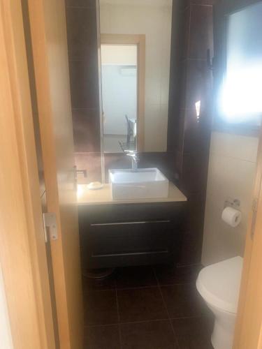 a bathroom with a sink and a toilet at Casa da Silva in Corroios