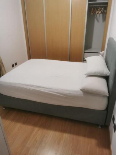 a bed with white sheets and pillows in a room at Casa da Silva in Corroios