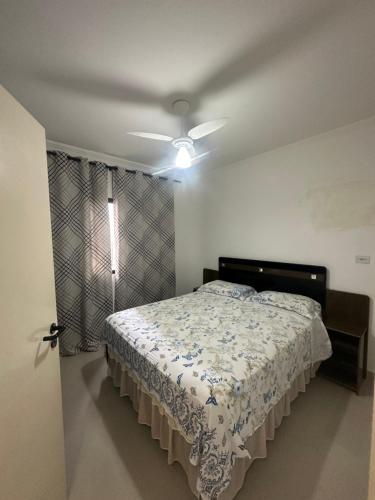 - une chambre avec un lit et un ventilateur de plafond dans l'établissement Cantinho da dona Maria, à Guarujá