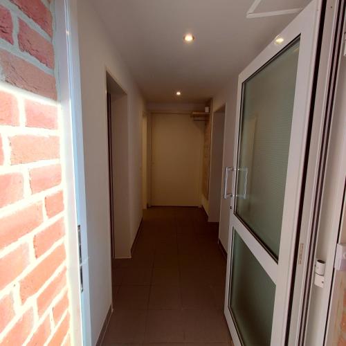 a hallway with a door and a brick wall at FeWo-Lieck in Heinsberg