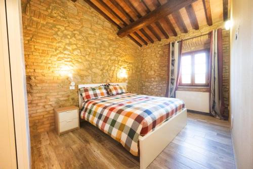a bedroom with a bed and a stone wall at Agriturismo Fonte Belvedere in Collesalvetti