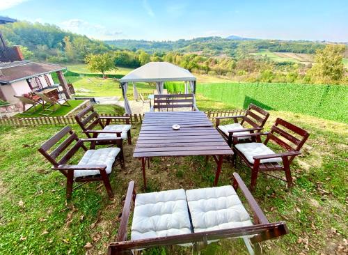 a wooden picnic table with chairs and a tent at Avala Sunset Apartments in Belgrade