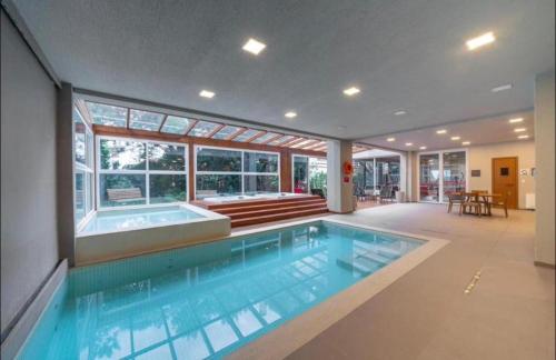 a large swimming pool with a tub in a house at Hotel Laghetto Stilo Borges in Gramado