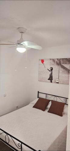 a bedroom with a white bed and a ceiling fan at Centro Catedral Carrera 27, 1 plaza de aparcamiento y NETFLIX gratis in Jaén