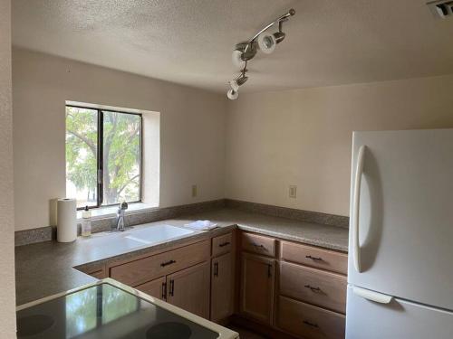 an empty kitchen with a sink and a refrigerator at One Bedroom Executive Condo Close to UNR and TMCC in Reno