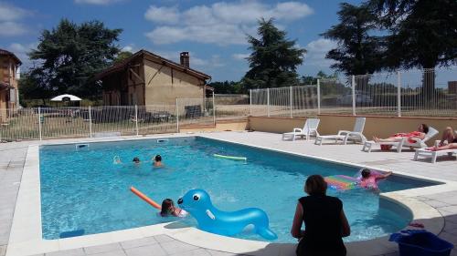 un groupe d'enfants jouant dans une piscine dans l'établissement Relais du Haget, à Cravencères