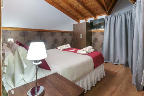 a bedroom with a large bed with a lamp on a table at Cabañas Tierra Mistica in Ushuaia