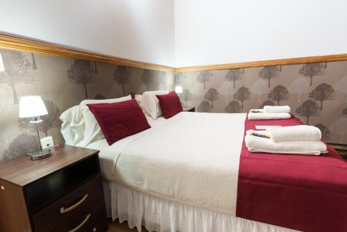 a bedroom with a large white bed with red pillows at Cabañas Tierra Mistica in Ushuaia