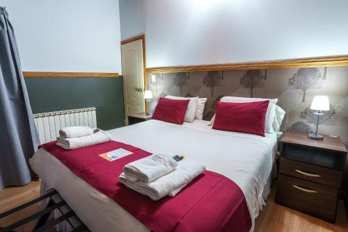 a bedroom with a large bed with towels on it at Cabañas Tierra Mistica in Ushuaia
