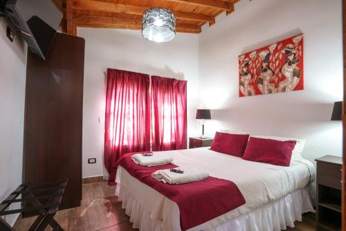 a bedroom with a large bed with red curtains at Cabañas Tierra Mistica in Ushuaia