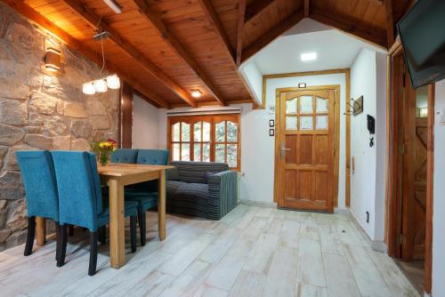 a dining room with a wooden table and blue chairs at Cabañas Tierra Mistica in Ushuaia