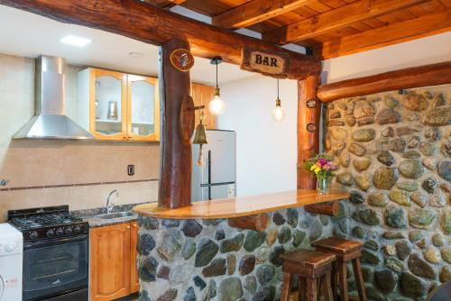 cocina con pared de piedra y encimera en Cabañas Tierra Mistica en Ushuaia
