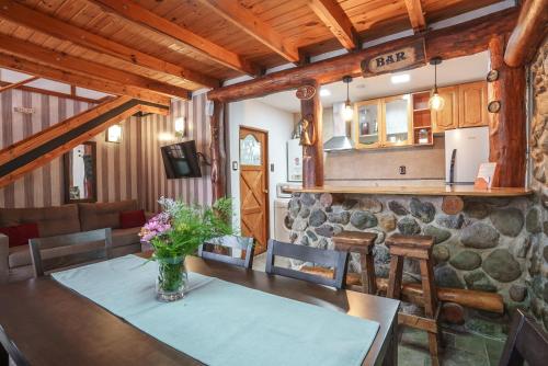 a dining room and kitchen with a stone wall at Cabañas Tierra Mistica in Ushuaia