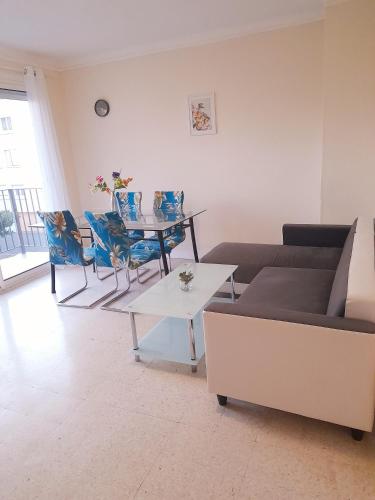 a living room with a couch and a table and chairs at Appartement F3 avec balcon in Perpignan