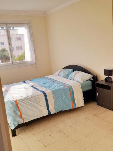 une chambre avec un lit et une fenêtre dans l'établissement Appartement F3 avec balcon, à Perpignan