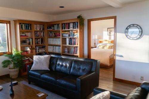 a living room with a leather couch and a bedroom at Sierra Lake View at Rubicon by Tahoe Getaways - 3 BR, Panoramic Lake Views, Private Hot Tub & Private beach! in Tahoma
