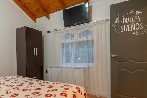 a bedroom with a bed and a television on the wall at Cabañas Tierra Mistica in Ushuaia