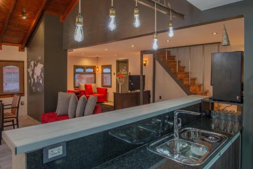 a kitchen with a sink and a living room at Cabañas Tierra Mistica in Ushuaia