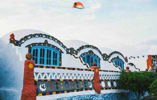 a kite flying in the sky over a building at Nuba Narty in Aswan