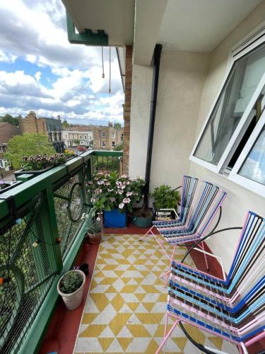 a balcony with chairs and potted plants on it at Contemporary 1BD Flat wBalcony - Stoke Newington! in London
