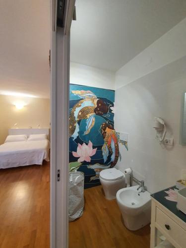 bagno con un dipinto sulla parete e servizi igienici di B&B METRO' a Perugia