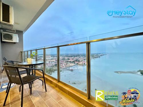 balcón con mesa y vistas al océano en Silver Scape Residence Melaka Raya By Heystay Management en Melaka