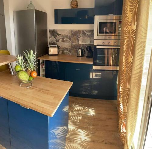 una cucina con piano di lavoro e forno a microonde di KARUK'IDîLE-Appartement Vue Mer - Plage à 200m a Gourbeyre