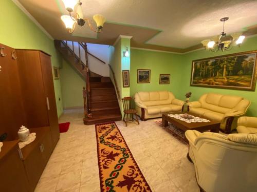 a living room with two couches and a staircase at Vila Lumja in Tirana