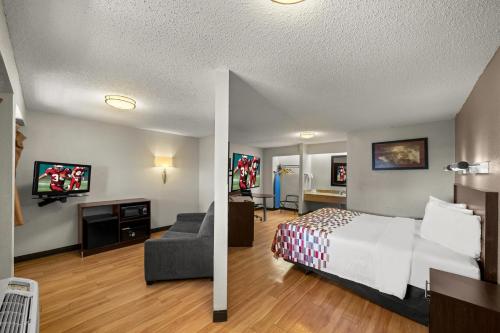 a hotel room with a bed and a living room at Red Roof Inn Dallas - DFW Airport North in Irving