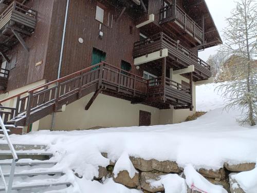 a building in the snow with snow covered stairs at les chalets de puy st vincent in Puy-Saint-Vincent