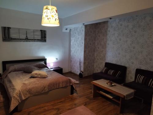 een slaapkamer met een bed en een bank bij Milu Residence in Ghimbav