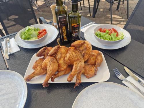 a plate of chicken on a table with salad at Pri štorklji in Moravske Toplice