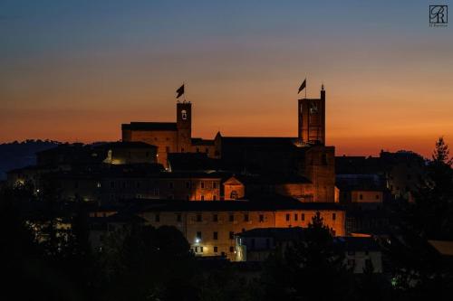 a building with two flags on top of it at sunset at Palazzo Rossi, Historic Boutique Home in Marche in Sarnano