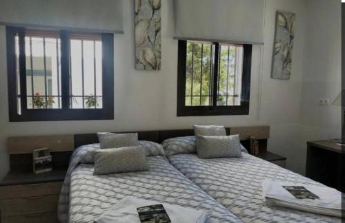 Albanchez de ÚbedaにあるHotel Rural Aznaitínのベッドルーム1室(ベッド2台、窓2つ付)