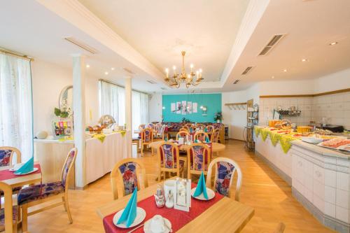 cocina y comedor con mesas y sillas en Hotel St. Martin, en Marktoberdorf