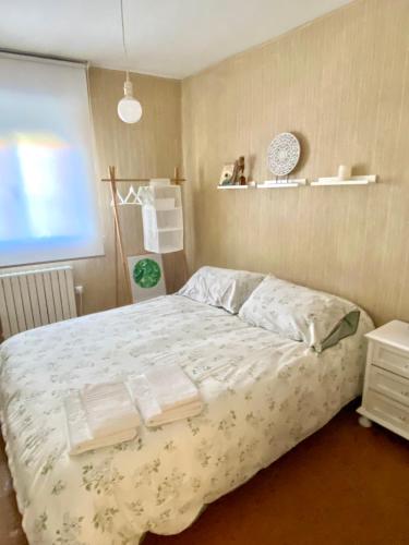 1 dormitorio con 1 cama con toallas en A casa do pai, en Pontevedra