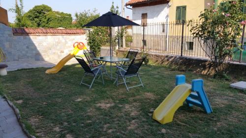 a backyard with a table and chairs and an umbrella at Bed and Breakfast Giaveno in Giaveno