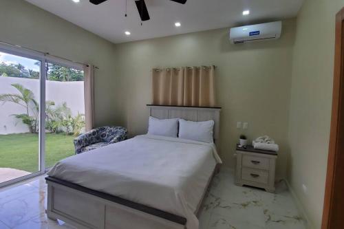 1 dormitorio con cama y ventana en So Lovely Apartment near Bonita Beach, en Las Terrenas