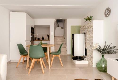 une cuisine et une salle à manger avec une table et des chaises vertes dans l'établissement CASA RELAX Appart cocooning dans village provençal, à Montfort-sur-Argens