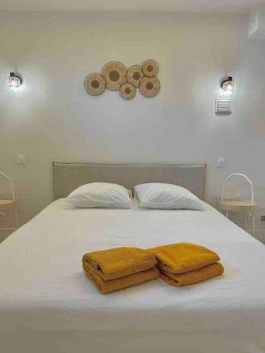 uma cama branca com duas toalhas em cima em Le BASHKIR em Nice