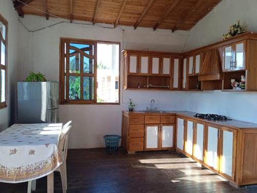 une cuisine avec des placards en bois et une table avec une table sidx sidx sidx dans l'établissement Hospedaje Paula C, à Calao