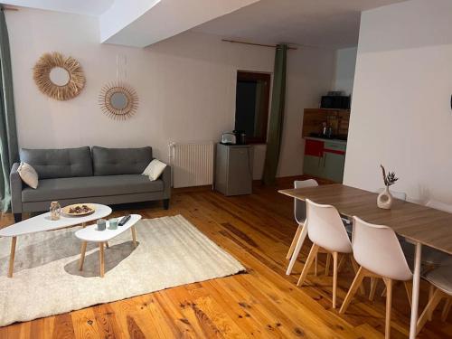 ein Wohnzimmer mit einem Sofa und einem Tisch in der Unterkunft Le chalet percheron in La Loupe