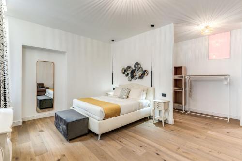 a white bedroom with a bed and a mirror at RIPETTA234 in Rome