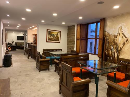 a waiting room with tables and chairs in a restaurant at Hotel Colonial - Casa Francisco in Quito