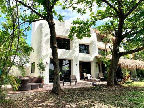 a white building with trees in front of it at *Villa Sicilia Lagoon front by Casa Paraiso* in Cancún