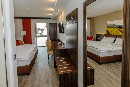 a hotel room with two beds and a mirror at Dorfmeister Business Hotel B&B in Weikersdorf am Steinfelde