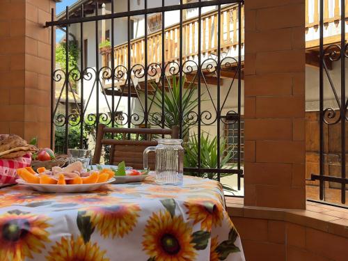 uma mesa com um prato de fruta numa toalha de mesa em Art apartment Alla casa del Gastaldo em Gorizia
