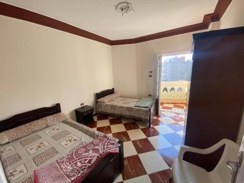 um pequeno quarto com 2 camas e piso em azulejo em شقق فندقيه برج شيفورليه حي الدولار em Marsa Matruh