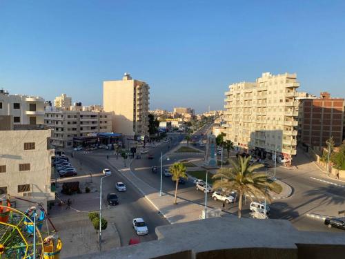 a city with a street with cars and buildings at شقق فندقيه برج شيفورليه حي الدولار in Marsa Matruh