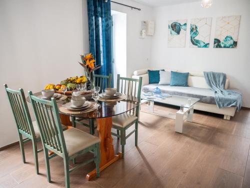 a dining room with a table and chairs and a couch at Isabela House in Ponta do Sol
